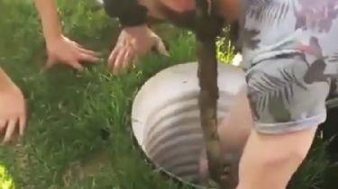 Un menor baja de cabeza por una tubería llena de agua para rescatar a una niña atrapada
