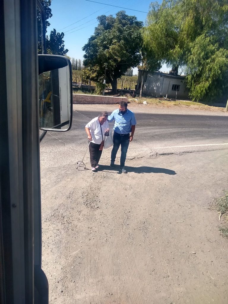 Chofer ayudando a la abuela a cruzar la calle 